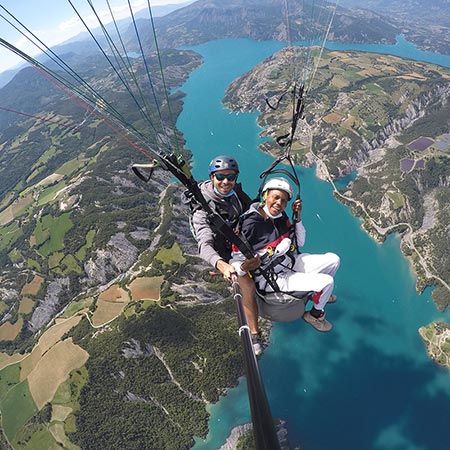 Equipage biplace parapente survolant en altitude le lac de Serre-Ponçon