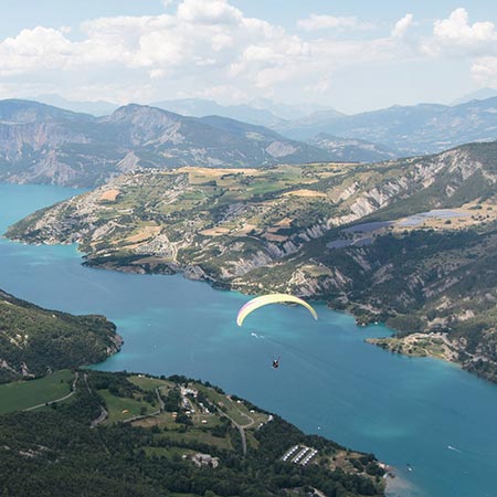 vue panoramique lac de serre-ponçon avec un parapente.